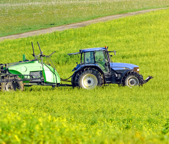 Ford/New Holland tractor with hay bale in the a field
